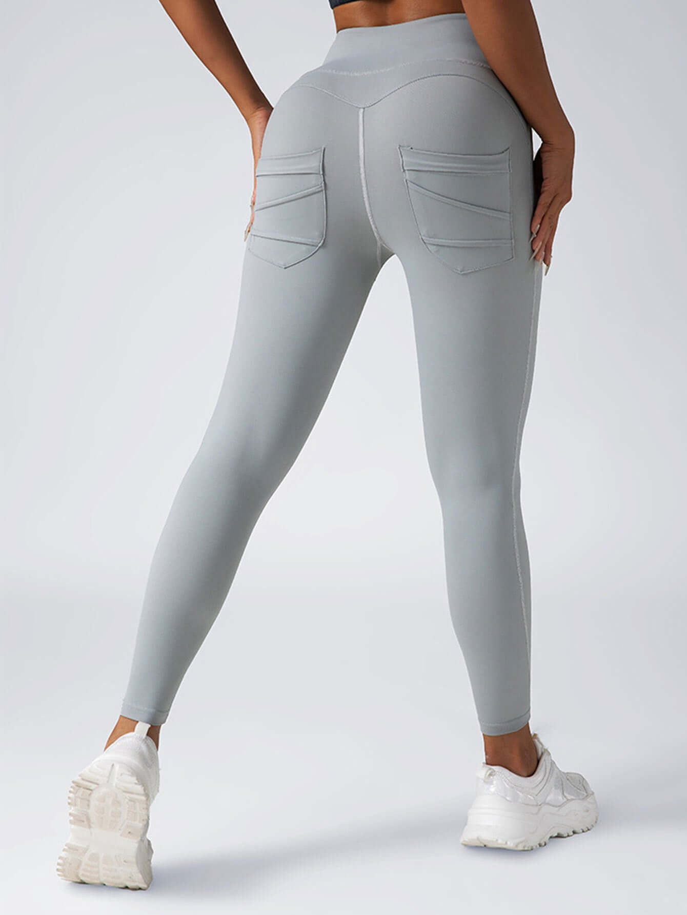 High-waisted women's yoga leggings in light gray with pockets, designed for comfort during workouts and casual wear.