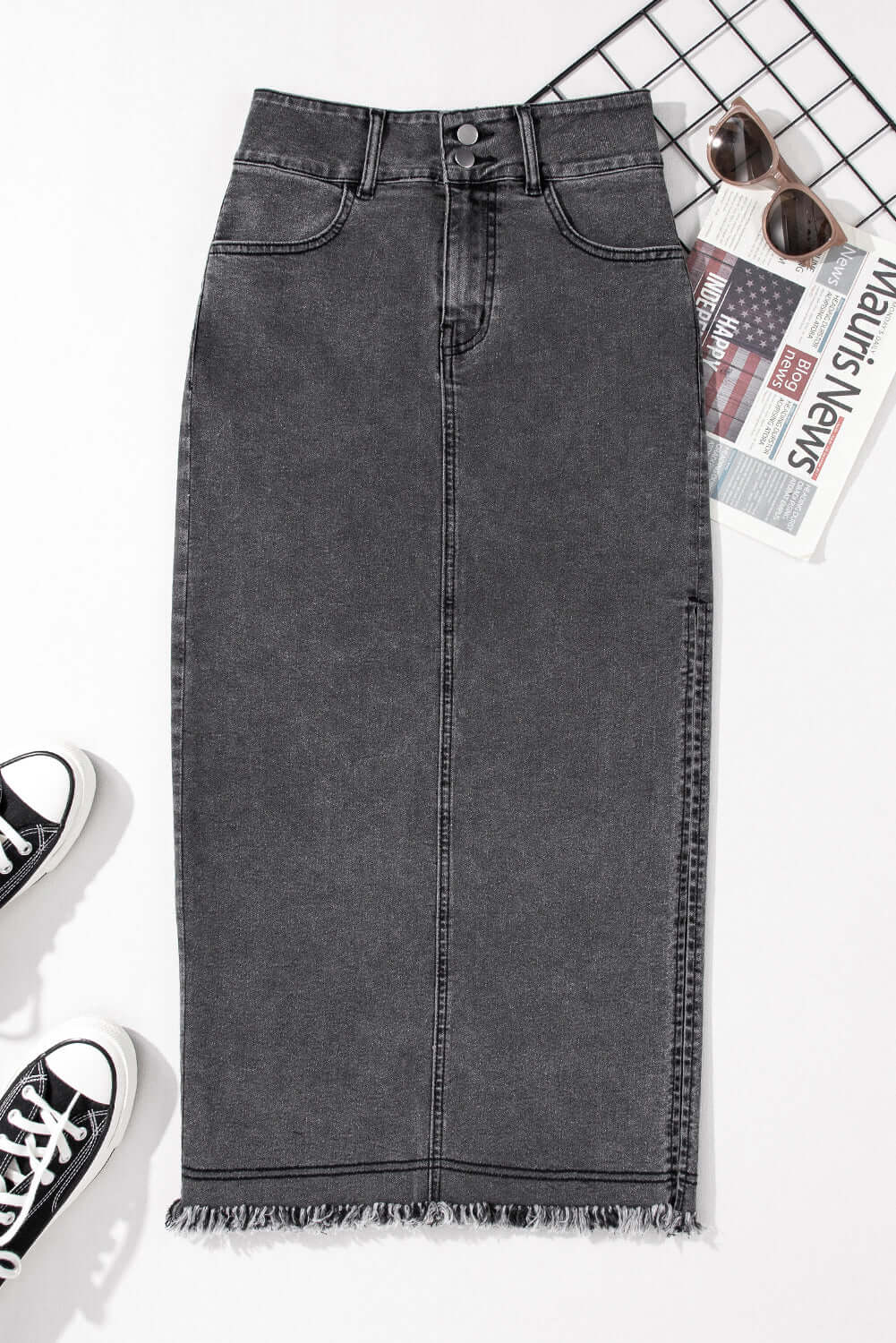 Black midi denim skirt with raw edge, side slits, and button closures, perfect for a casual, stylish look.