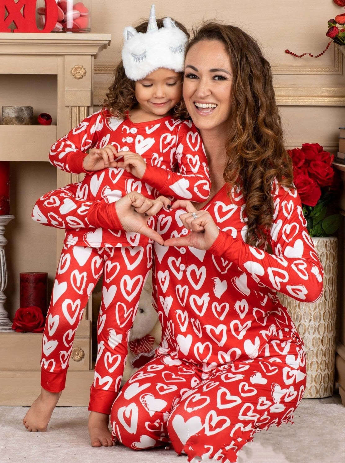 Mother and daughter in matching Valentine's Day heart print pajamas, celebrating love and togetherness.