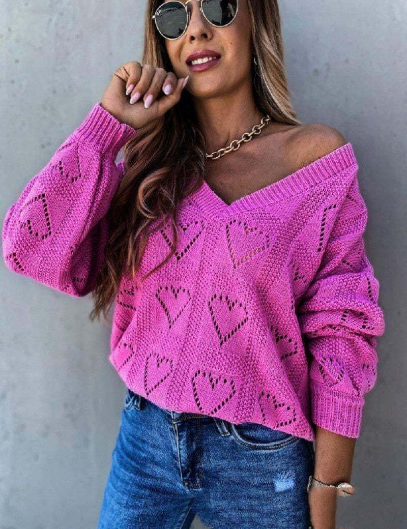 Pink hollow heart knit women's sweater with off-shoulder design.