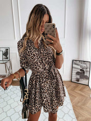 Leopard print short vintage dress for women, styled with a casual belt and half sleeves, displayed in a modern setting.