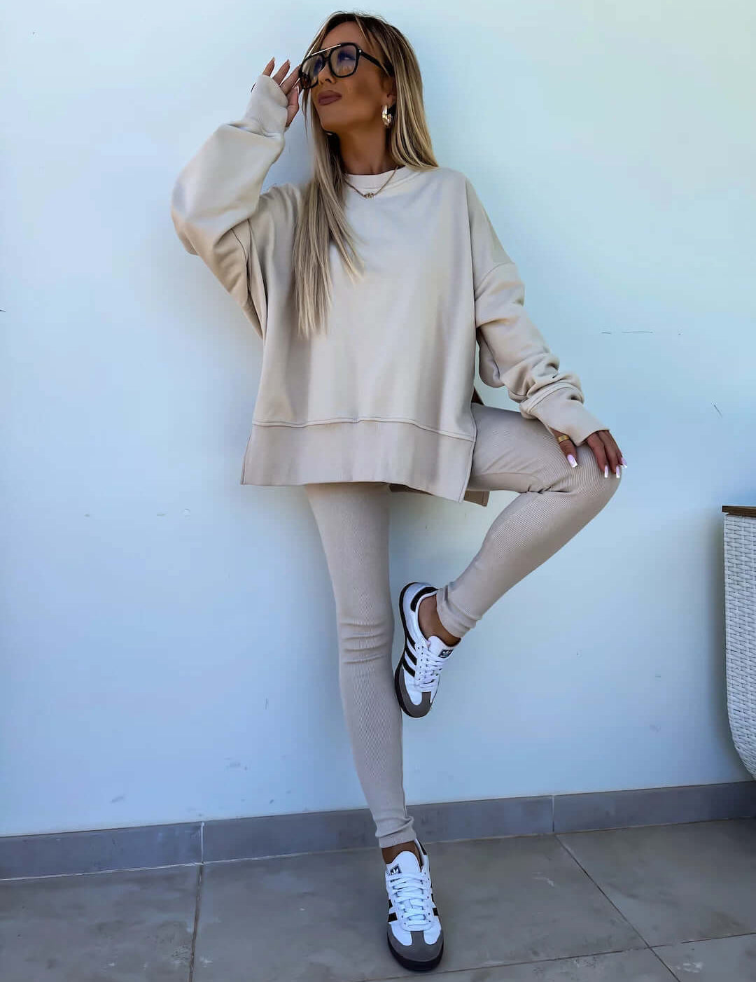 Women's casual loose long sleeve crew neck sweater suit in apricot with split top and tight trousers.