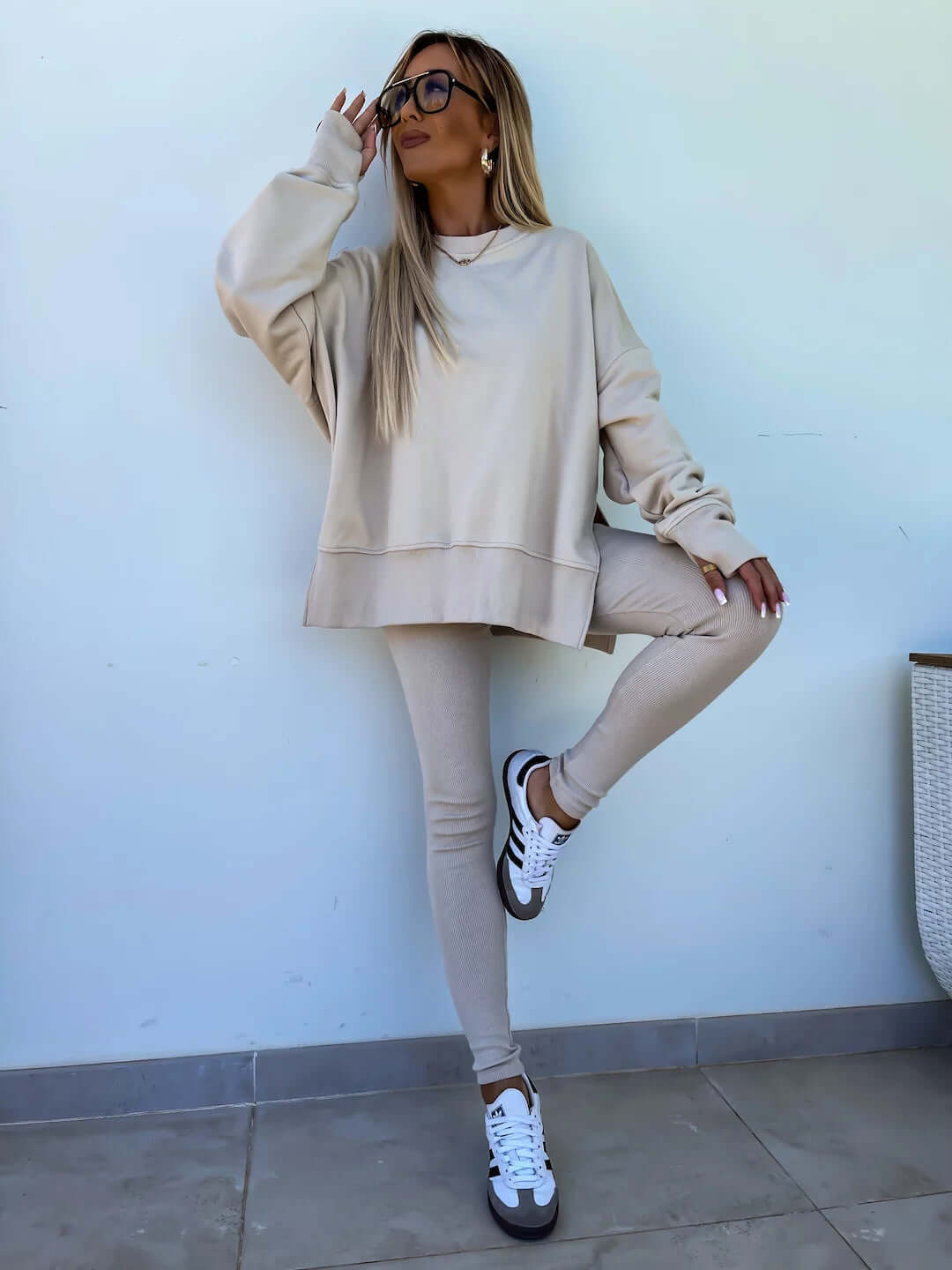 Women's casual loose long sleeve crew neck sweater suit in apricot with split top and tight trousers.