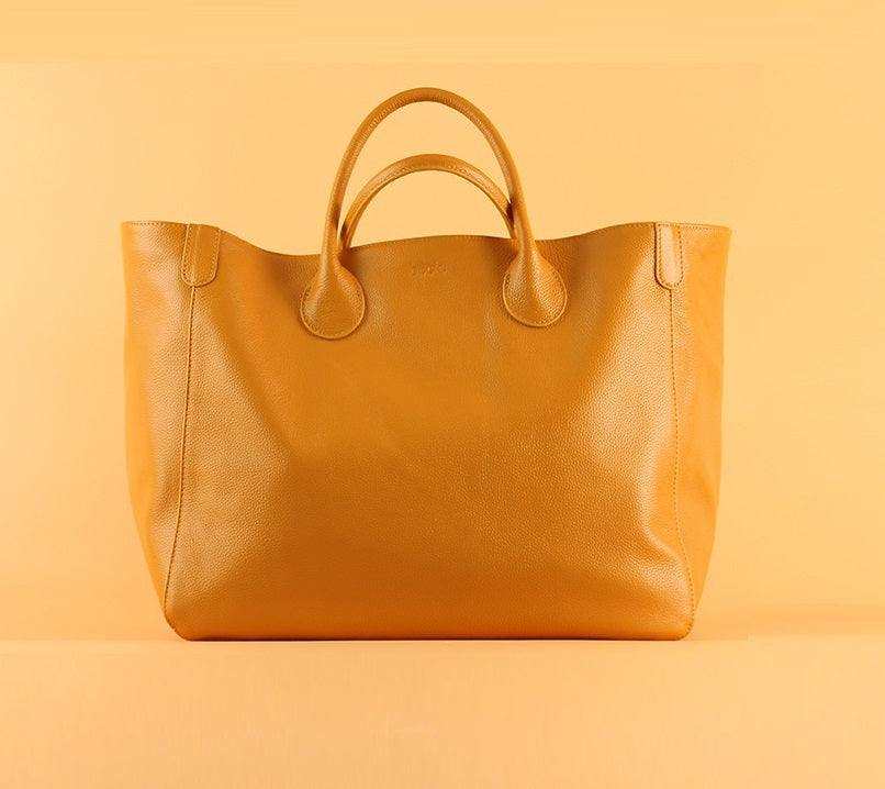 Fashionable ladies tote bag with top layer leather, hand-held design in tan color.