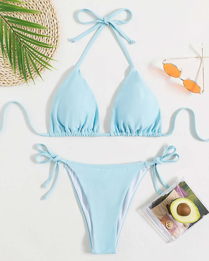 Light blue pure color tied halter bikini swimsuit with ties and briefs, displayed with sunglasses and a tropical vibe.