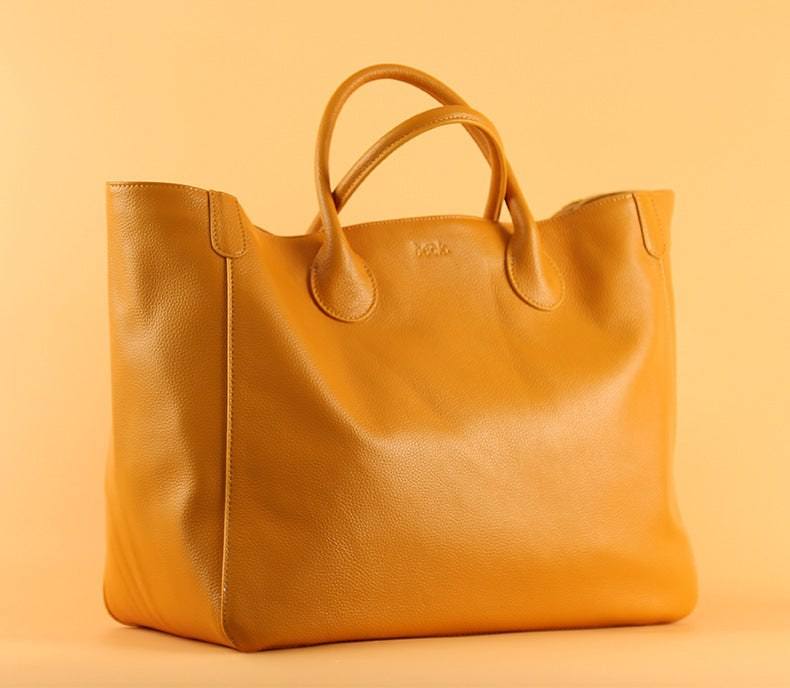 Top layer leather hand-held ladies tote bag with open design and cowhide material.