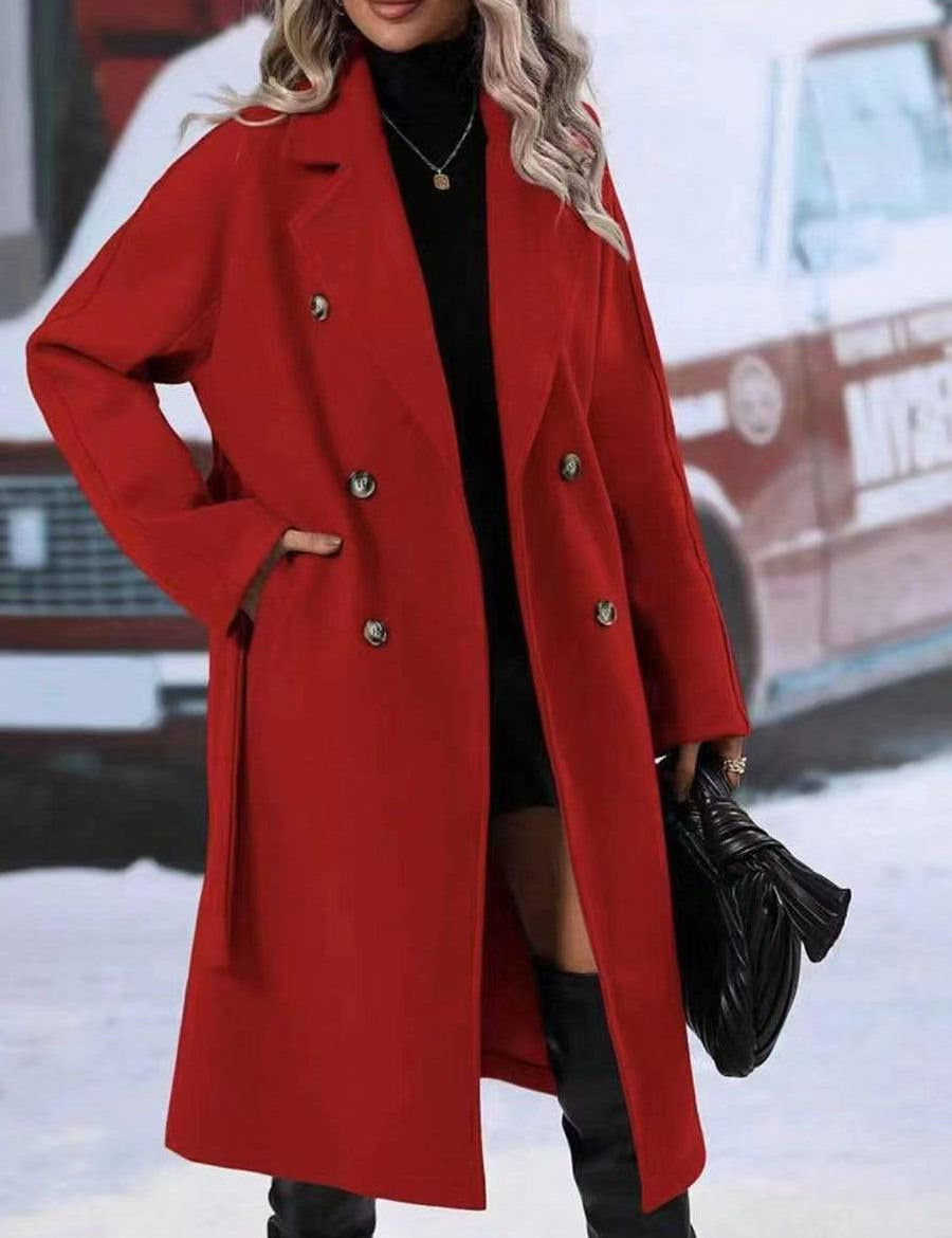 Women's long red double-breasted trench coat with belt and flip collar.