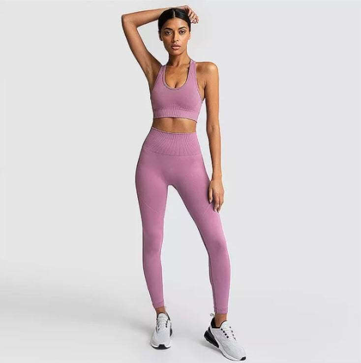 Women's pink yoga suit with high-waisted leggings and sports bra.