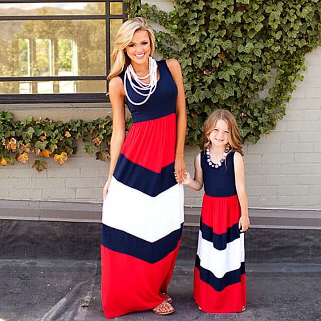 Mother and daughter in matching sleeveless long dresses with red, white, and navy blue color block design.