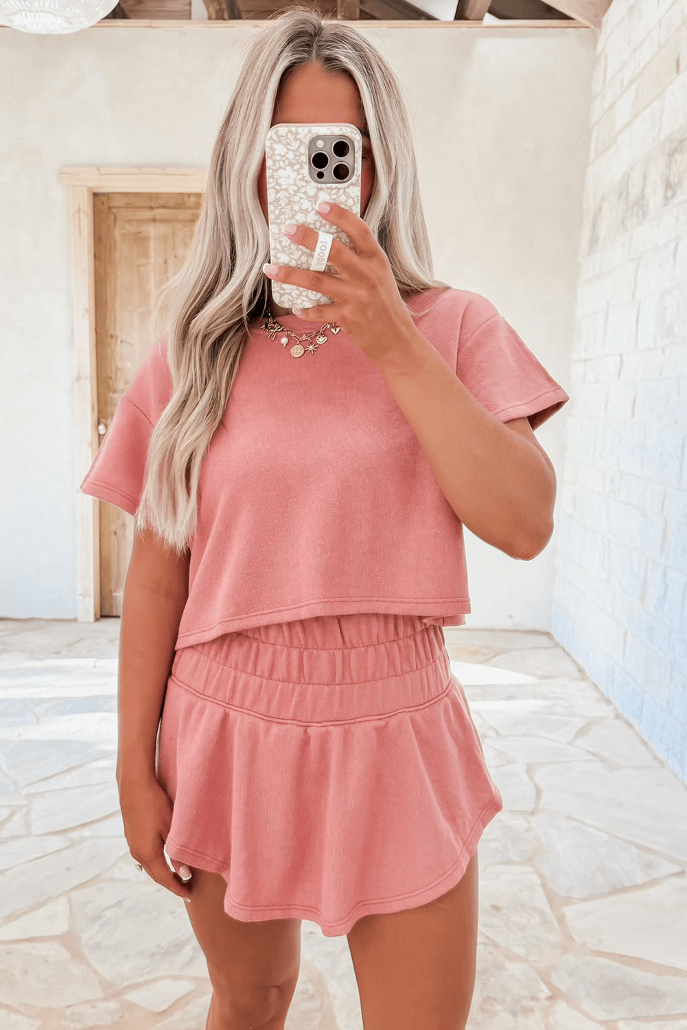 Woman wearing pink Blossom Cropped Tee and Ruffle High Waist Skort Set, showcasing casual summer style.