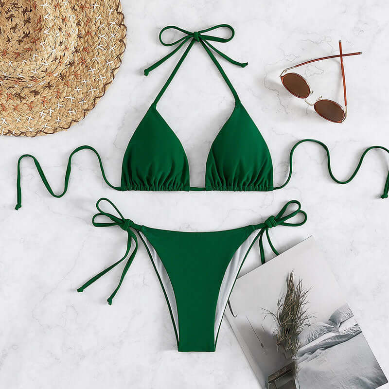 Green Pure Color Tied Halter Bikini Swimsuit with accessories on marble background.