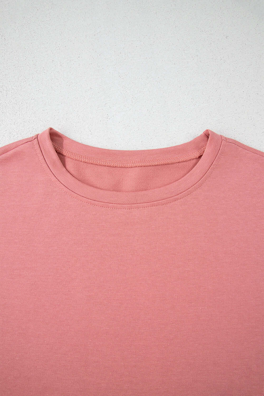 Close-up of the pink Blossom Cropped Tee showcasing its soft fabric and classic round neckline.