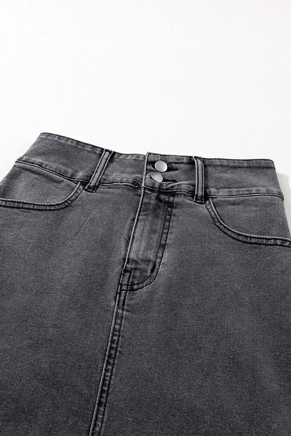 Black buttoned midi denim skirt with raw edge detail and high waist design, showcasing stylish metal buttons.