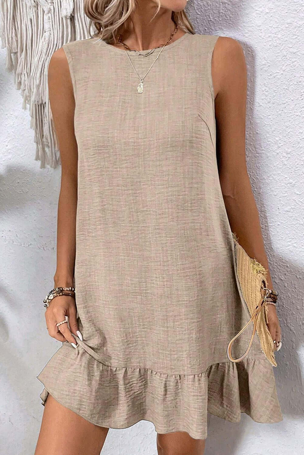 Light beige sleeveless mini dress with ruffle hem, perfect for casual summer outings.