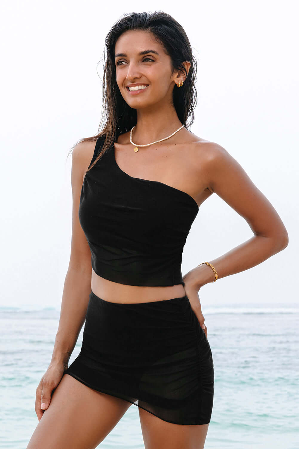 Black ruched mesh one shoulder bikini top and skirt set, beachwear for stylish summer looks.