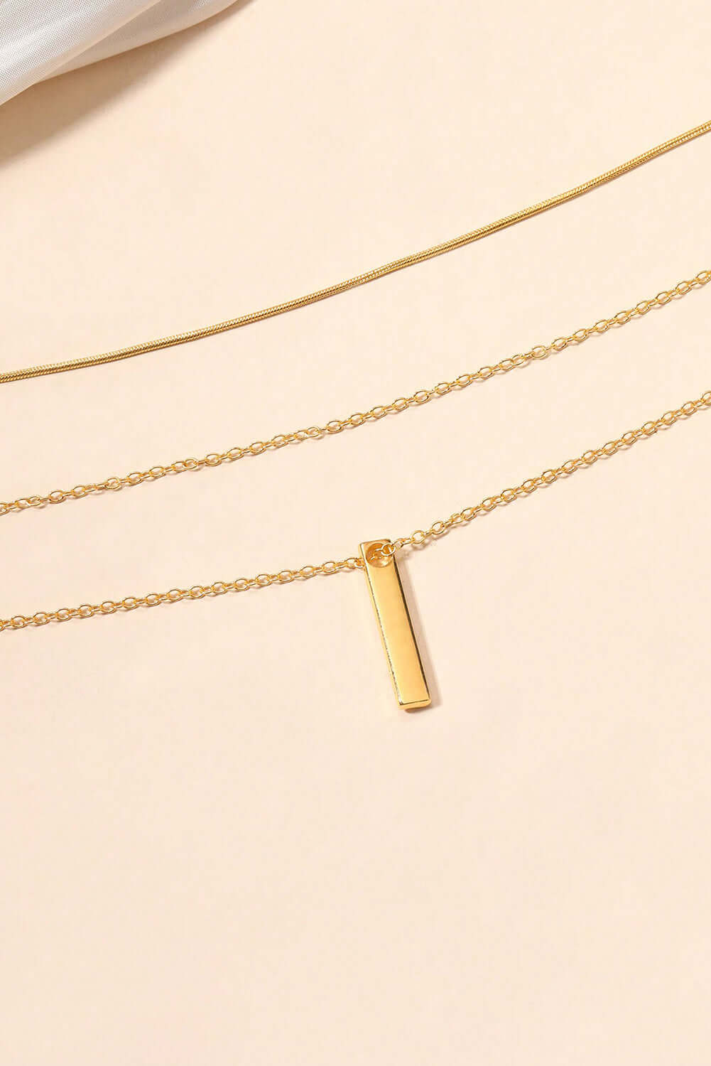 Elegant gold alloy layered chain necklace featuring a chic gold bar pendant, perfect for versatile styling.