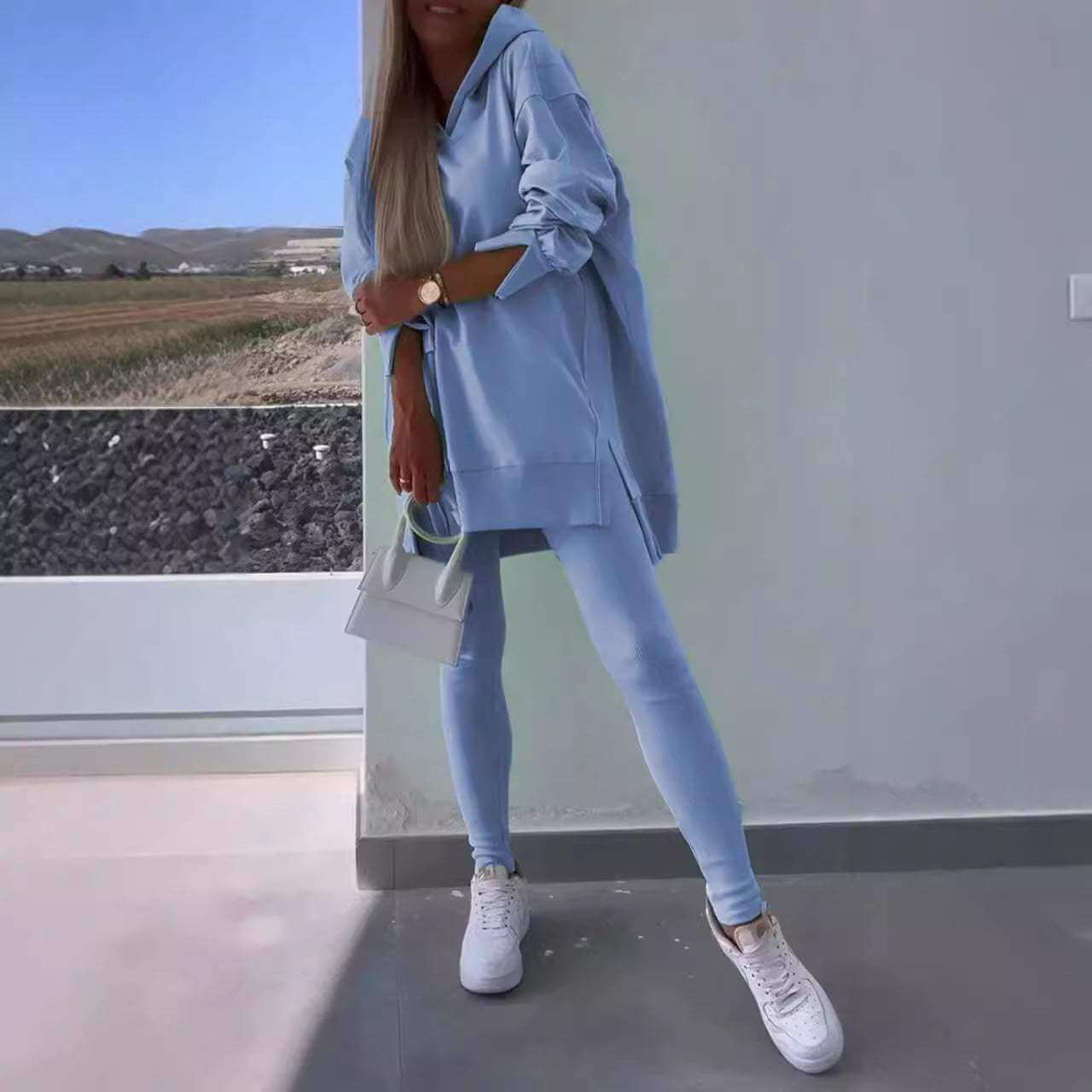 Women's blue hooded sweatshirt and tights set in street fashion style.