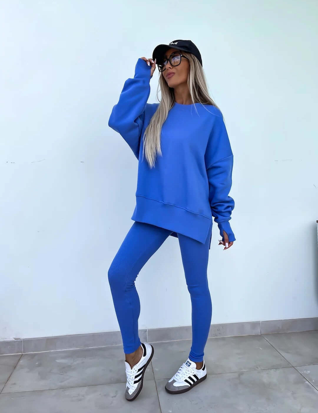 Women's casual loose long sleeve crew neck split top with tight trousers in blue.