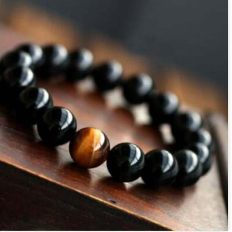 Black onyx and tiger eye stone energy bracelet with a beaded design.