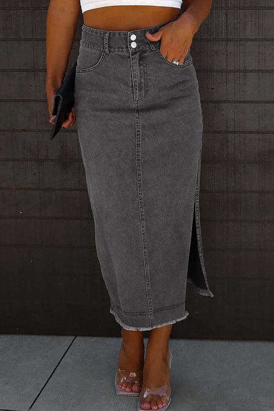 Black midi denim skirt with raw edge, side slits, and button closures, styled for a chic casual look.