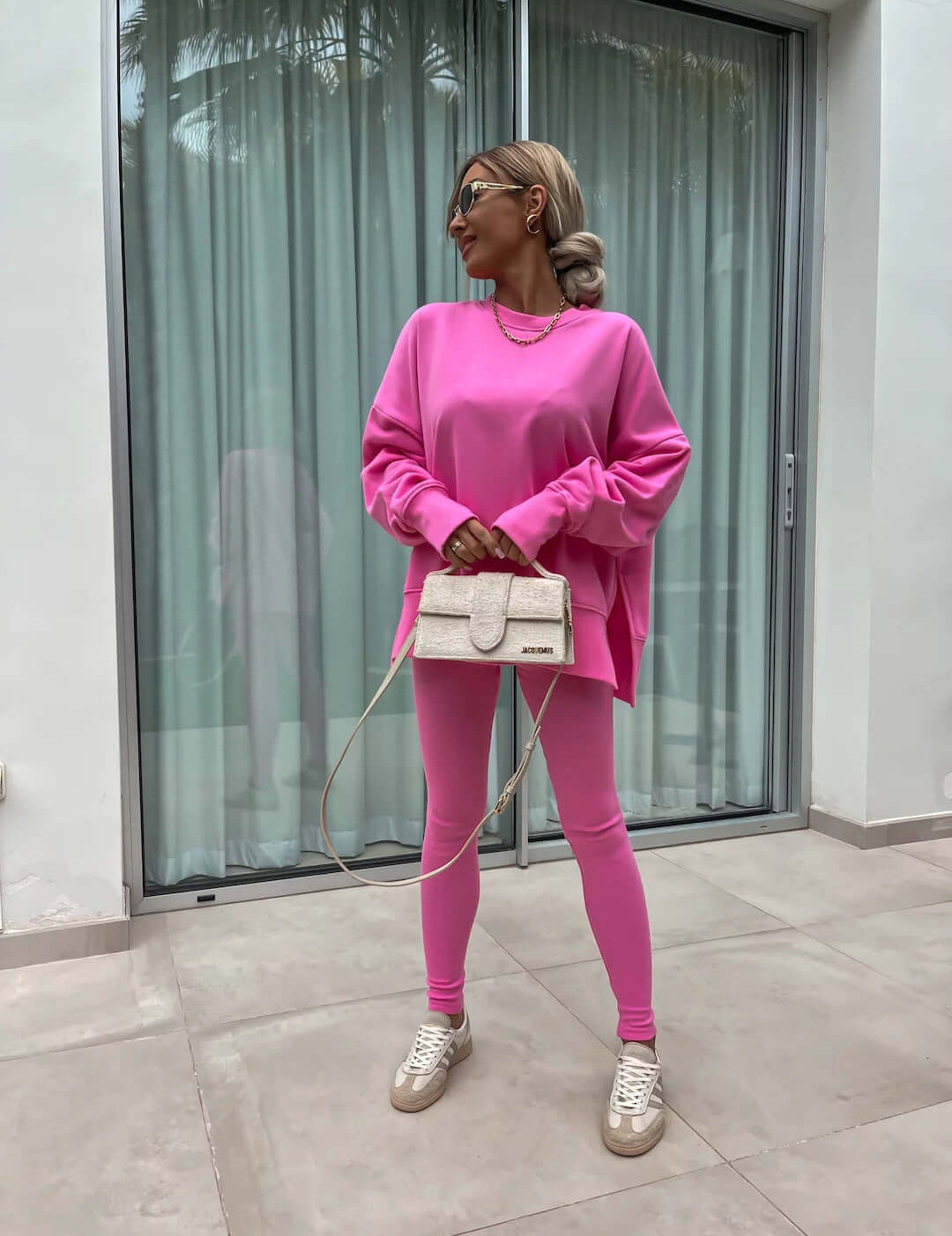 Women's casual loose long sleeve pink sweater suit with crew neck split top and tight trousers.