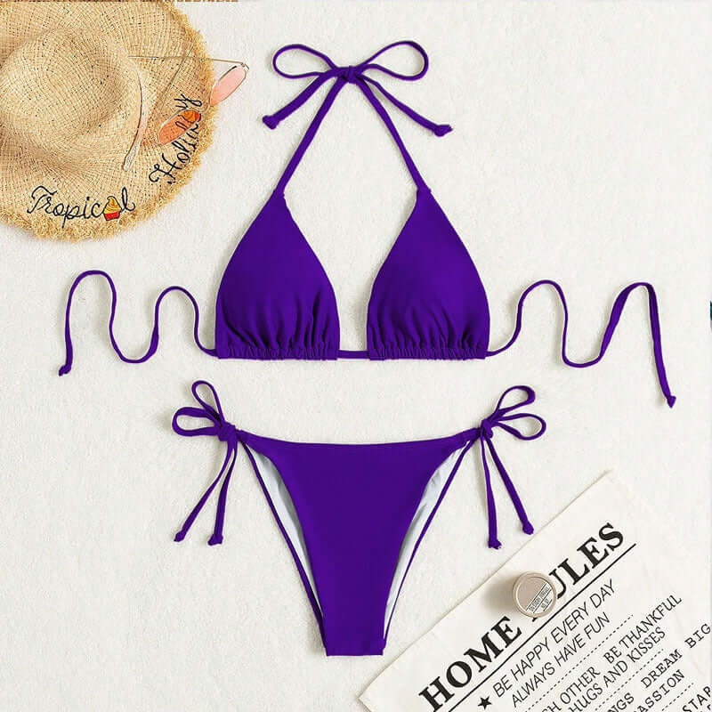 Purple Pure Color Tied Halter Bikini Swimsuit laid flat on a surface with accessories.