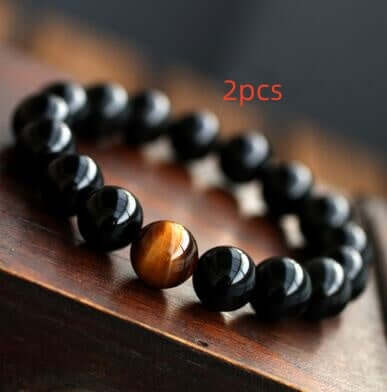 Natural Black Onyx with Stone Tiger Eyes Energy Bracelet on wooden surface.