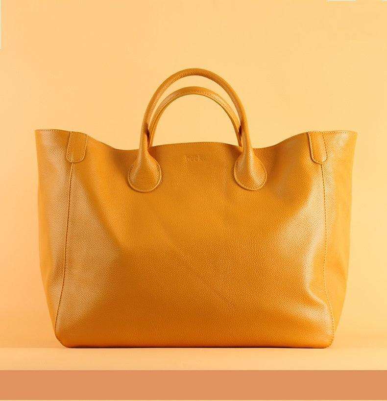 Top layer leather ladies tote bag in stylish design with hand-held handles.